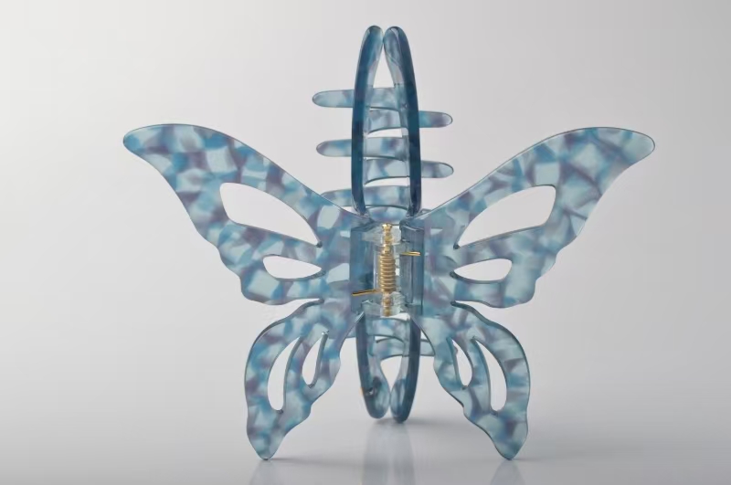 Blue patterned acetate butterfly-shaped eyewear frame with a visible spring hinge