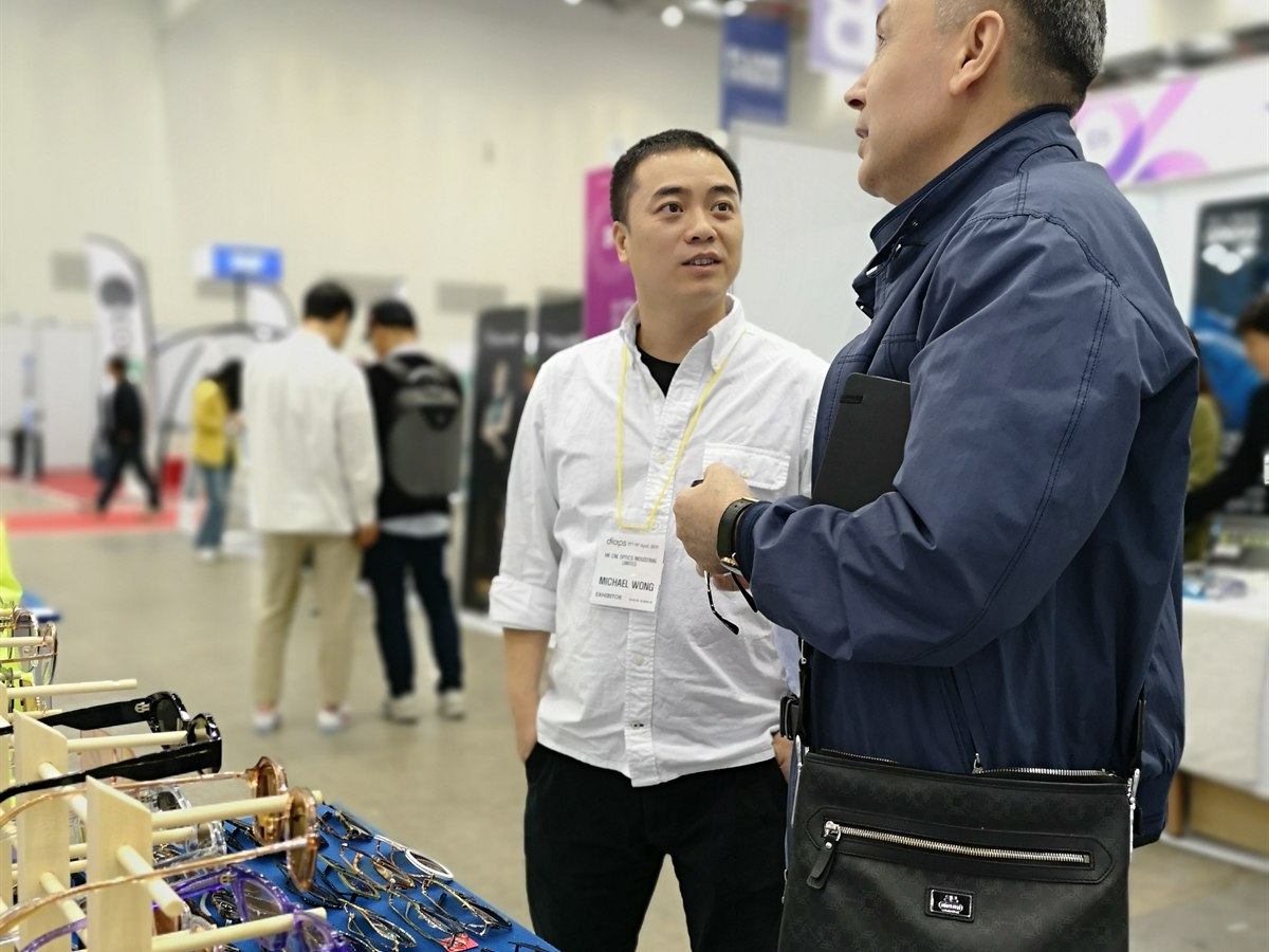 CNL Optics team member discussing eyewear samples with a buyer at a Korea trade show in 2019