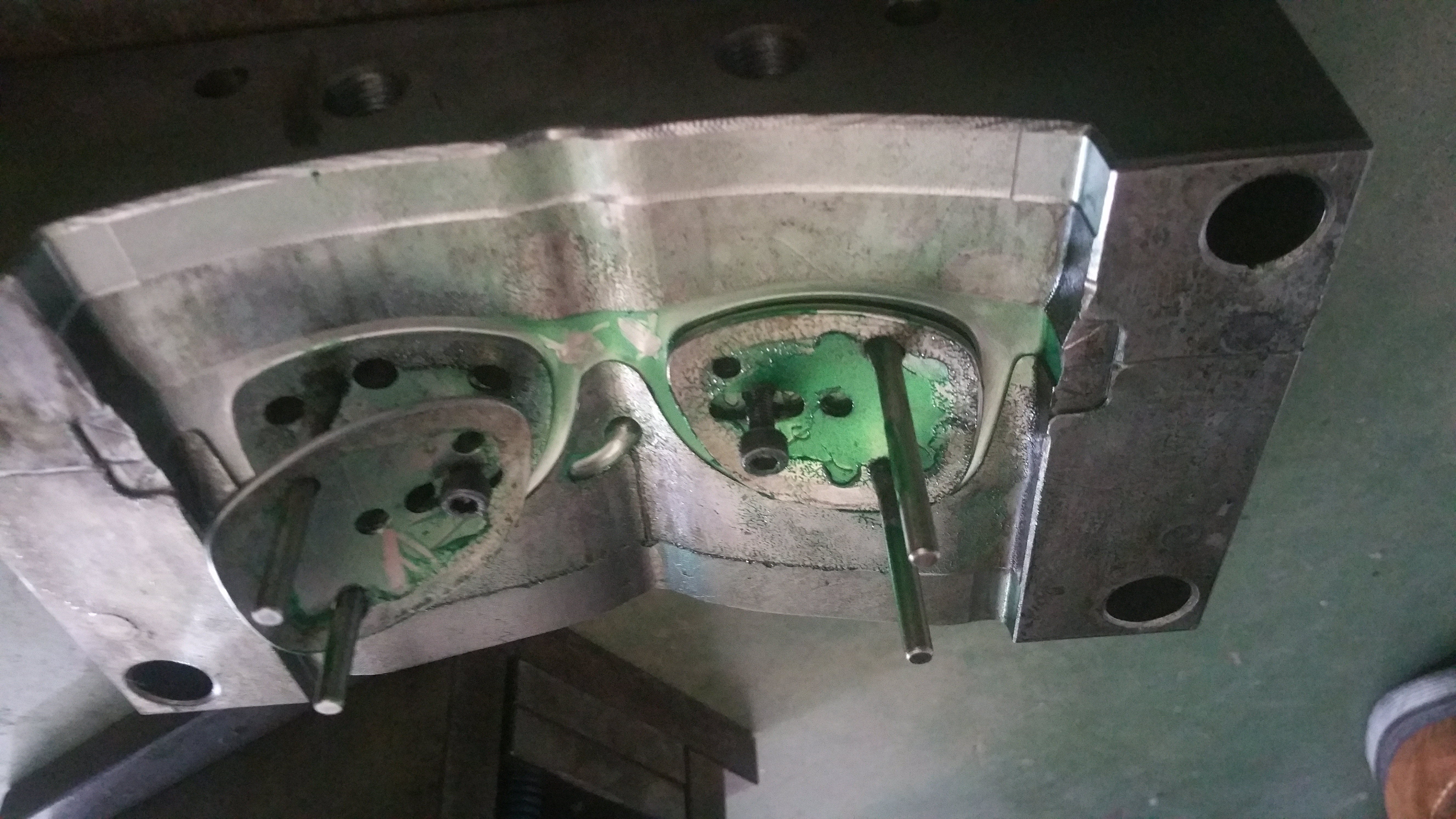 Open eyewear injection mold with frame cavities, locating pins and tooling surfaces