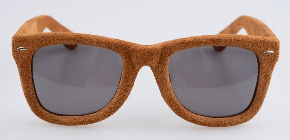 Brown suede-like material covering the full front and temples of a sunglasses frame