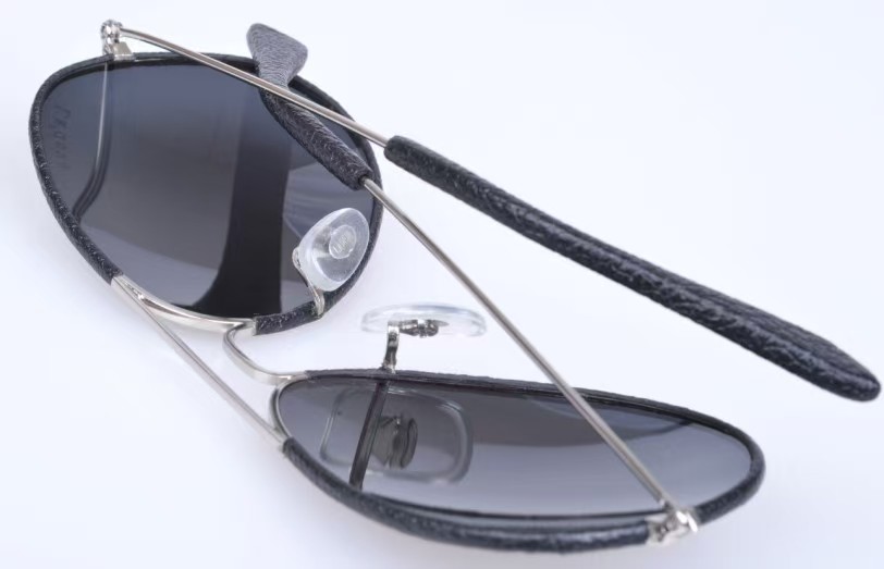 Metal eyewear with a textured leather-wrapped temple and nose bridge detail