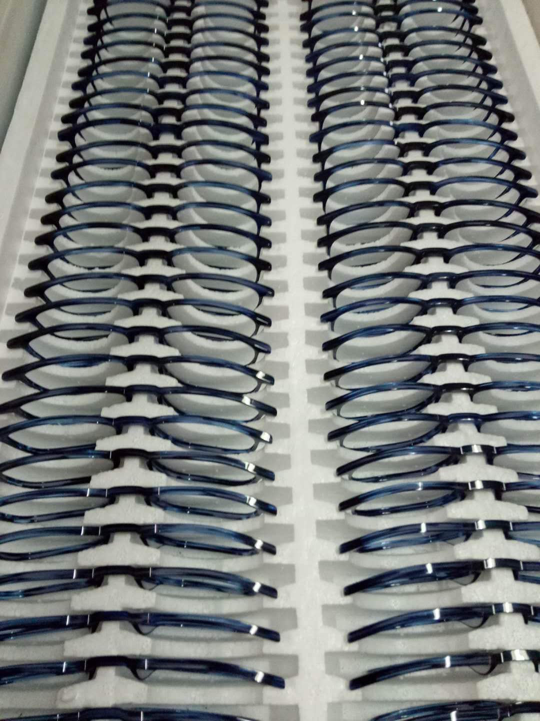 Finished blue optical frames placed separately in a protective tray